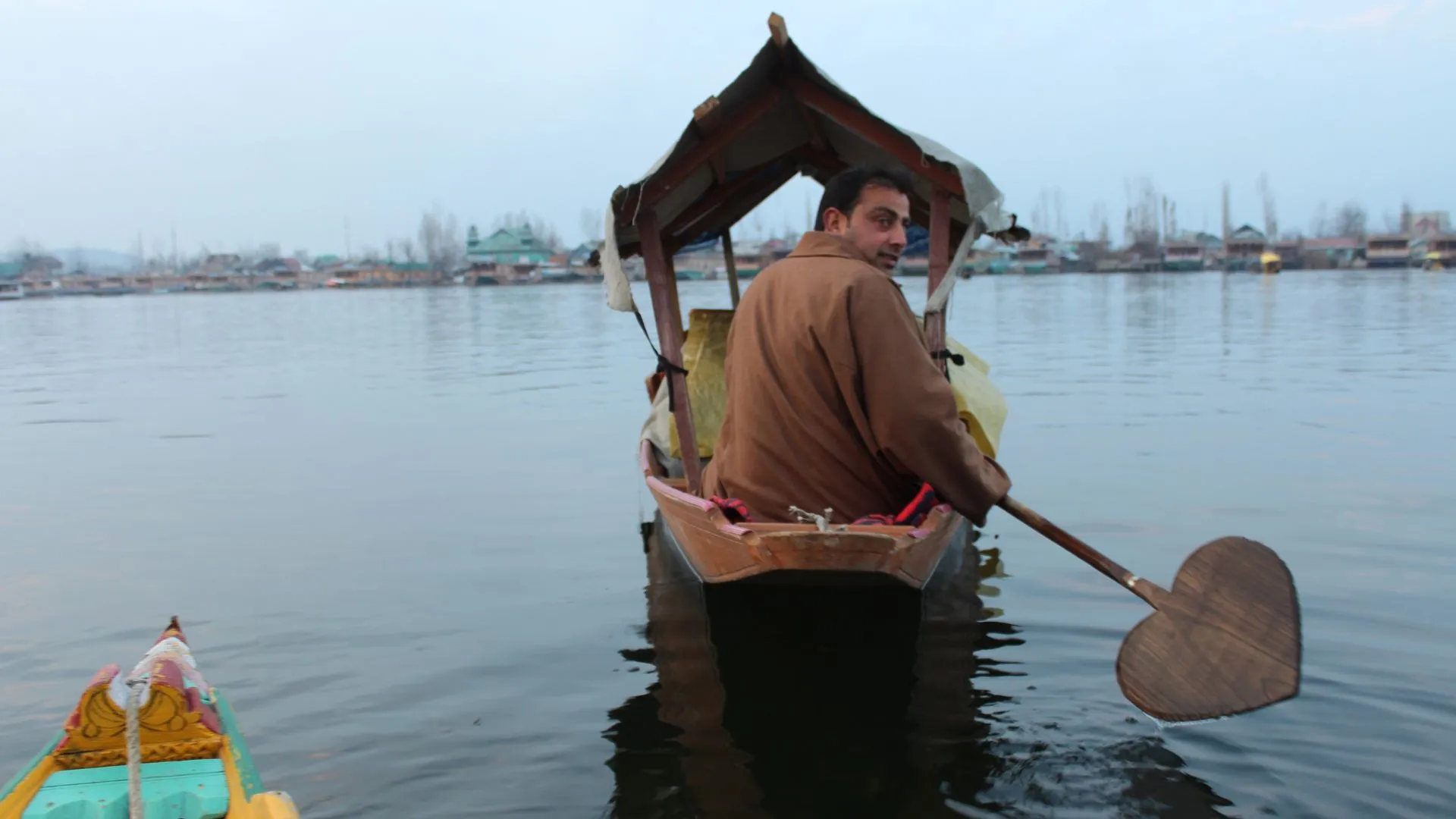 A man driving a traditional Thai boat