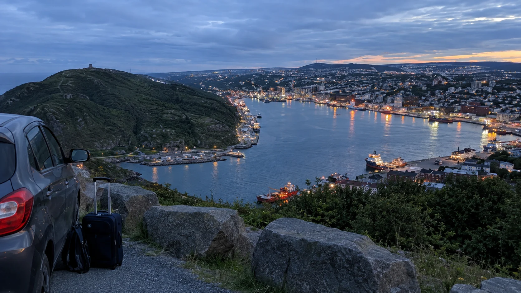Evening view over St. John's harbor from Signal Hill beside a parked car