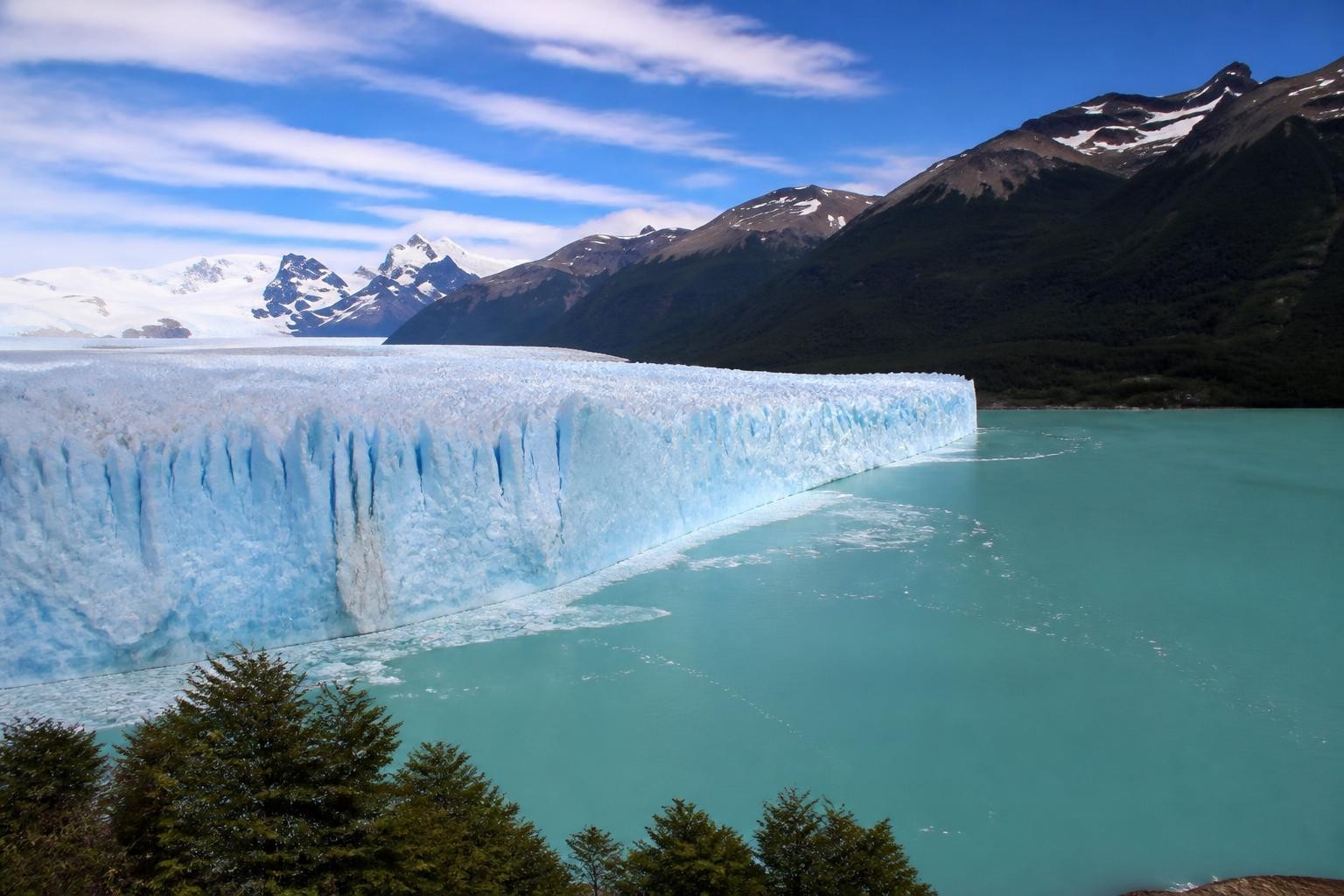 Blue ice wall of Perito Moreno Glacier above turquoise water