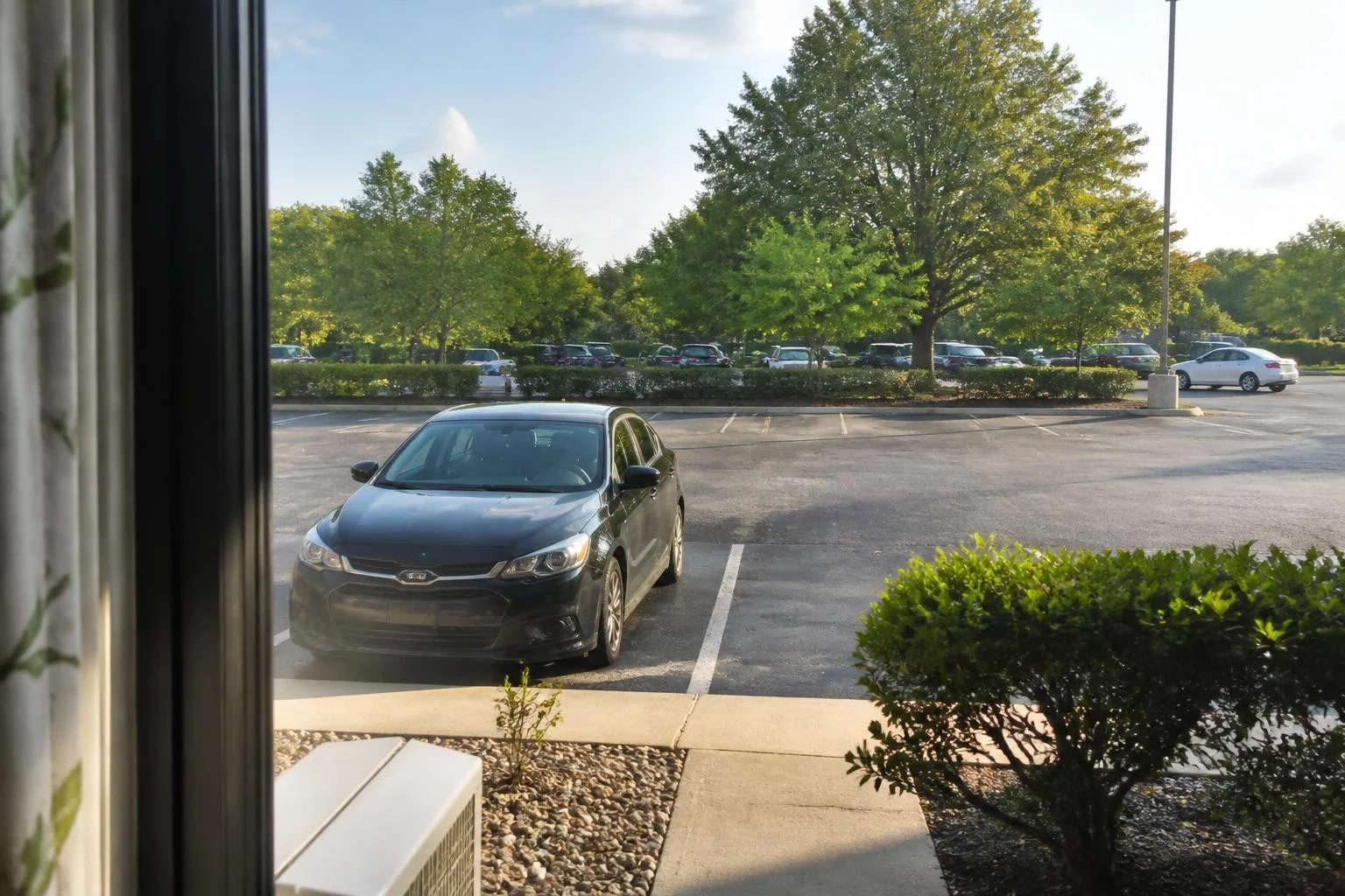 Well-lit hotel parking lot close to a guest room entrance