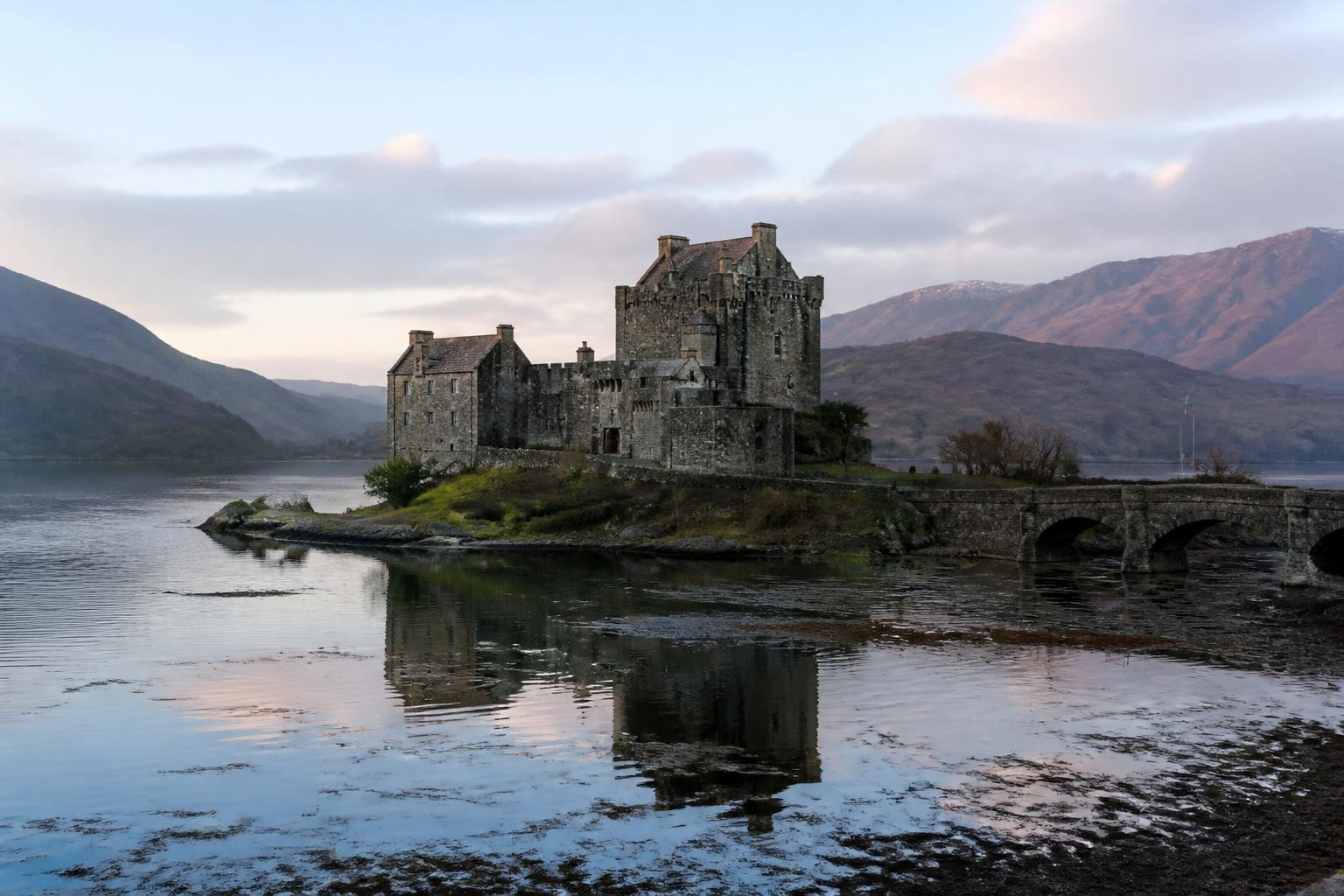 Eilean Donan Castle surrounded by water and Highland mountains