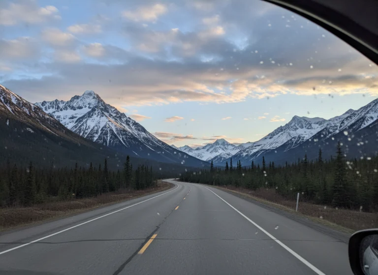 Alaska highway winding through snowcapped mountains between Seward and Denali
