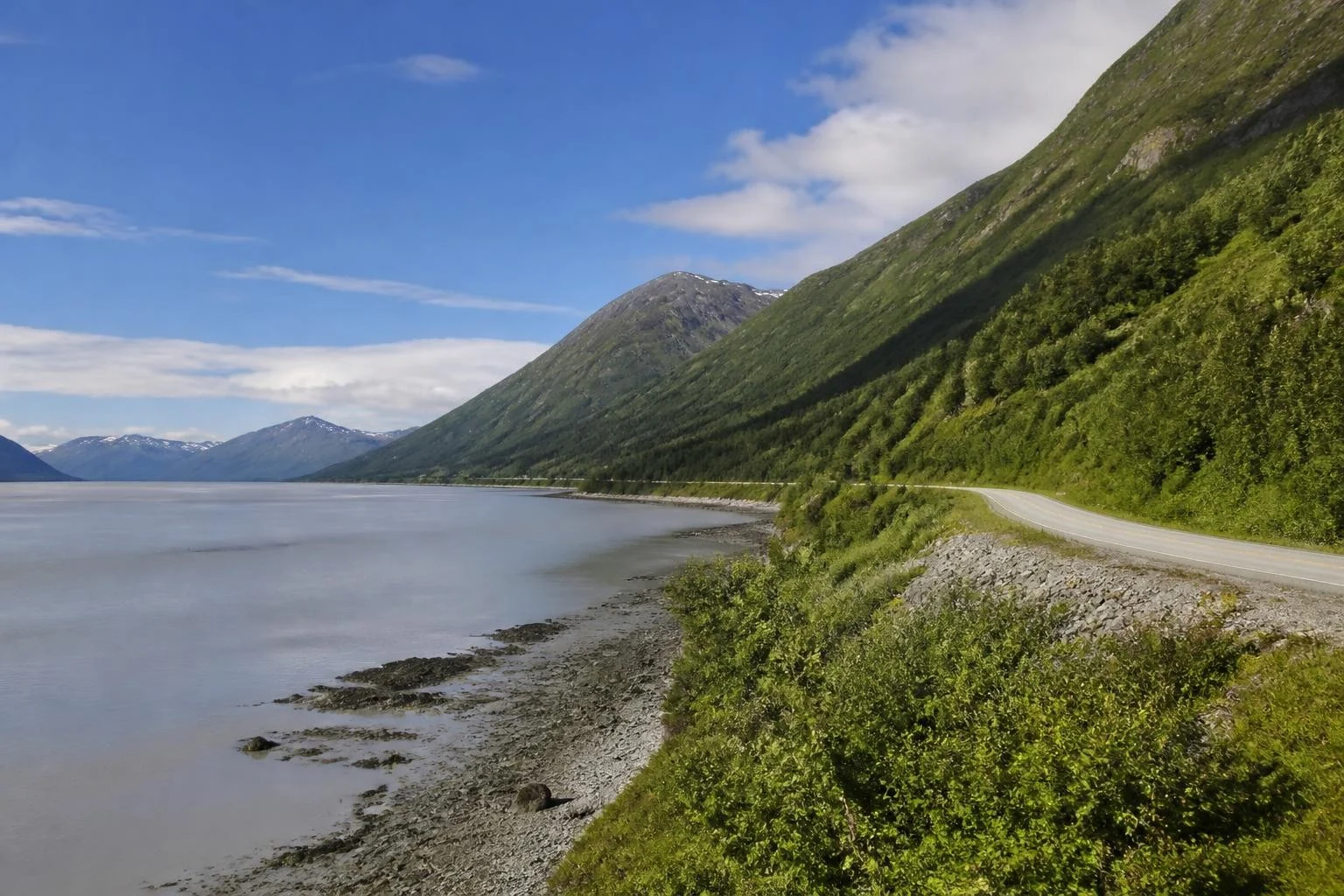 Scenic highway along Turnagain Arm beneath steep Alaska mountains