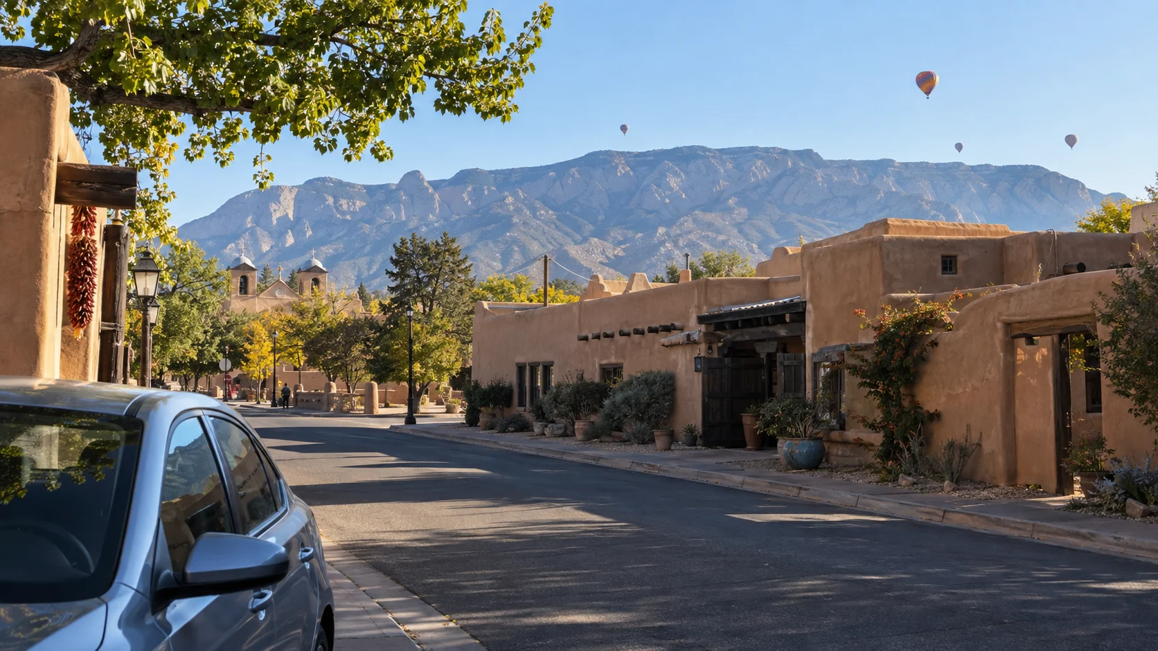 Adobe buildings, desert mountains and distant balloons define an Albuquerque morning.
