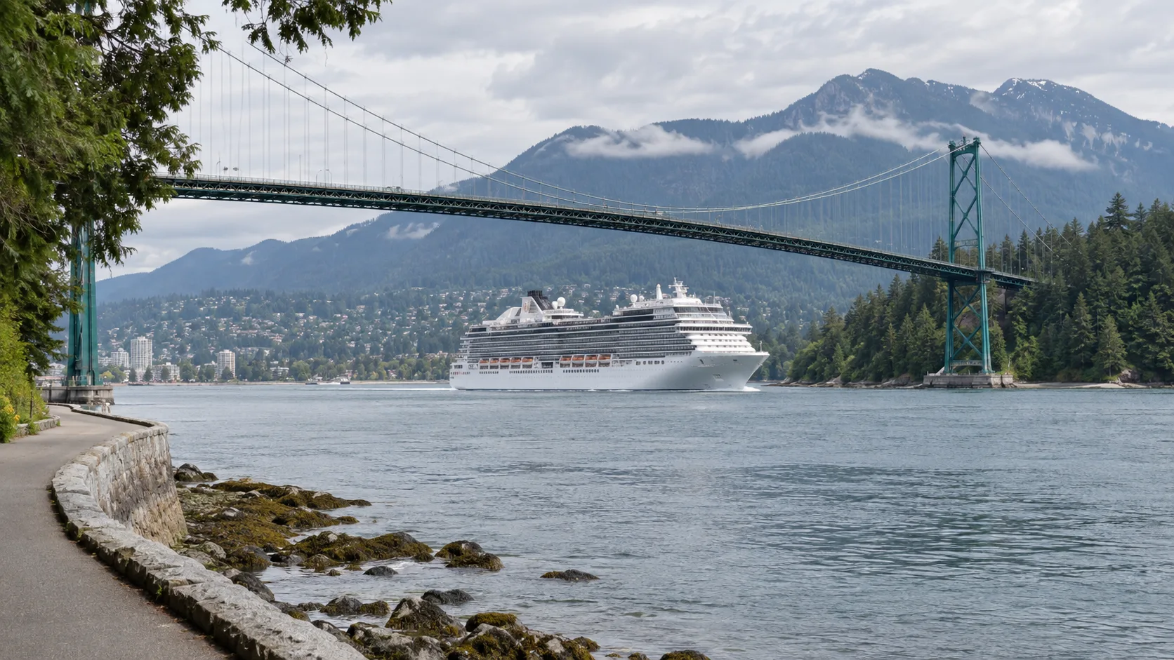 Cruise ship leaving Vancouver beneath the Lions Gate Bridge with coastal mountains ahead