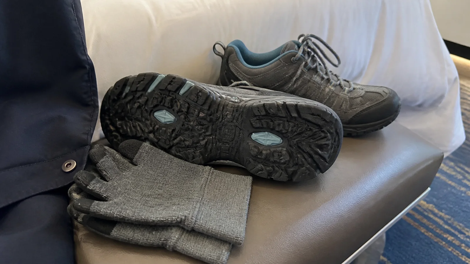 Hiking shoes and gloves rest on a cabin seat.