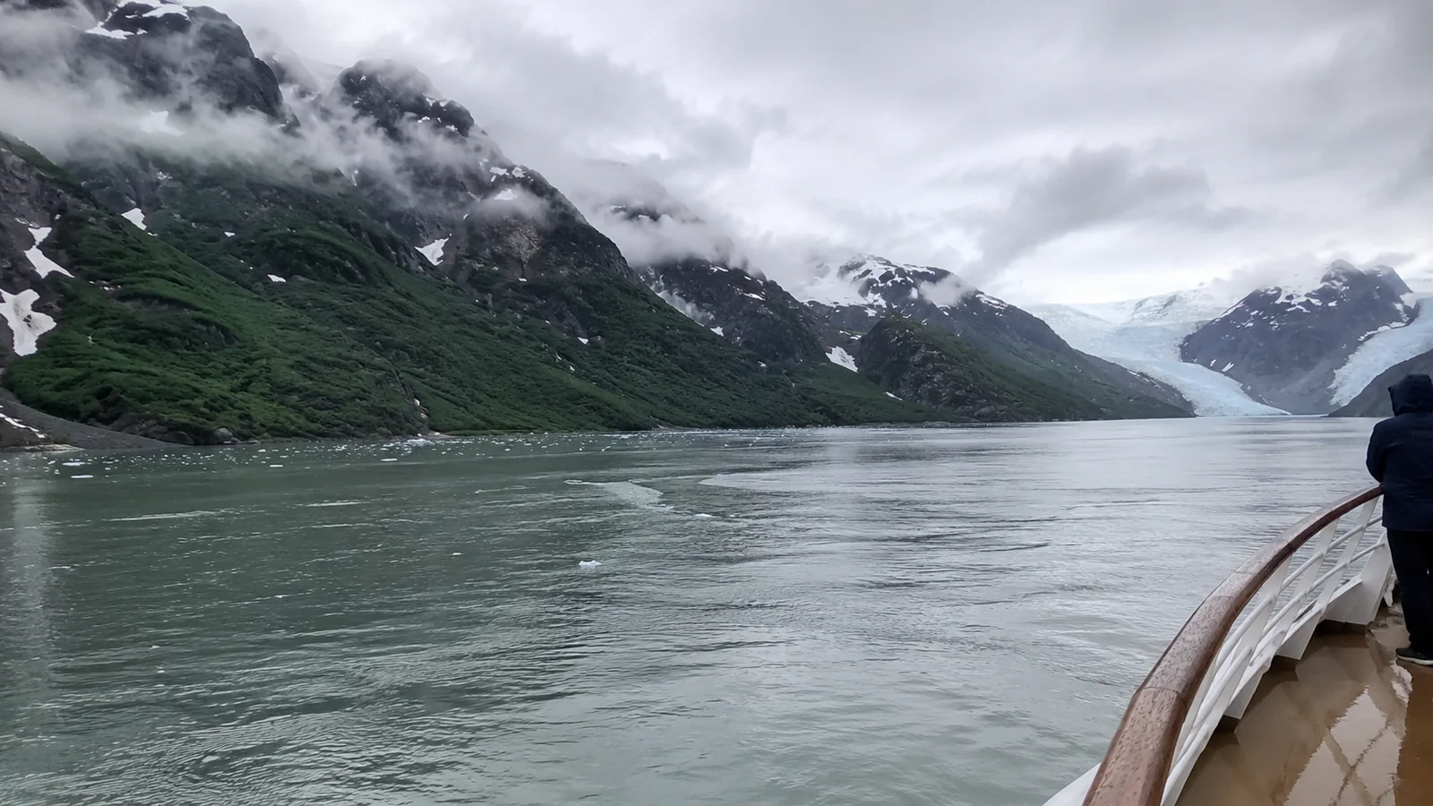 Cloudy glacial bay and mountains viewed from a cruise ship