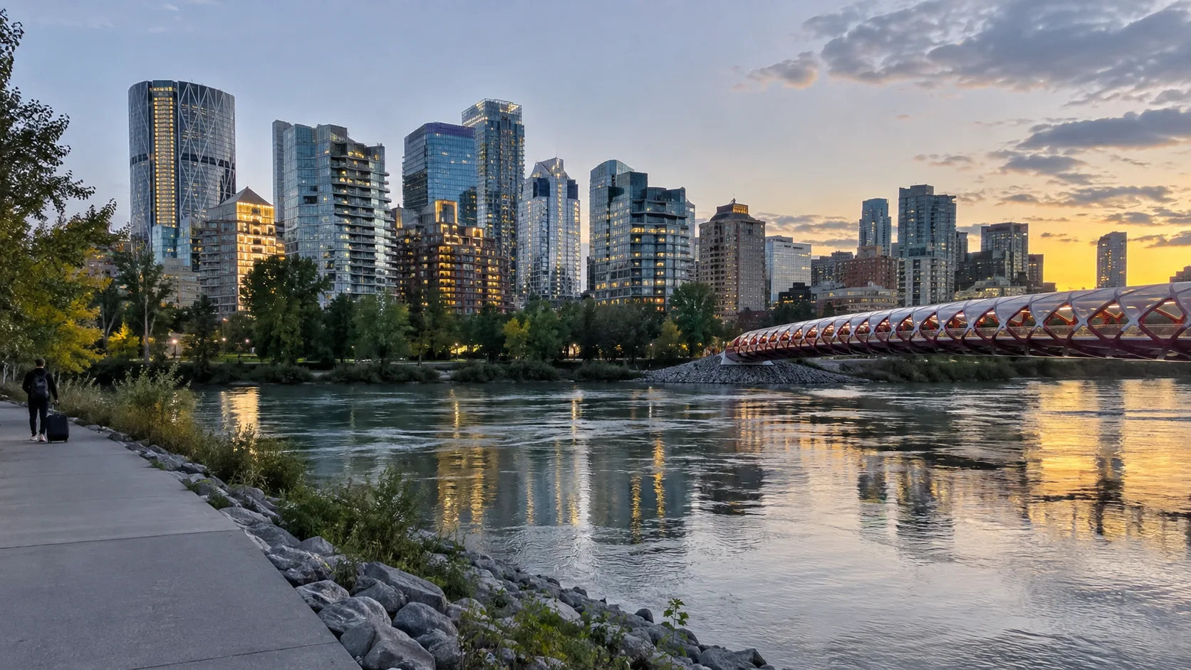 Traveler arriving beside Calgary's Bow River with the downtown skyline and Peace Bridge at sunset