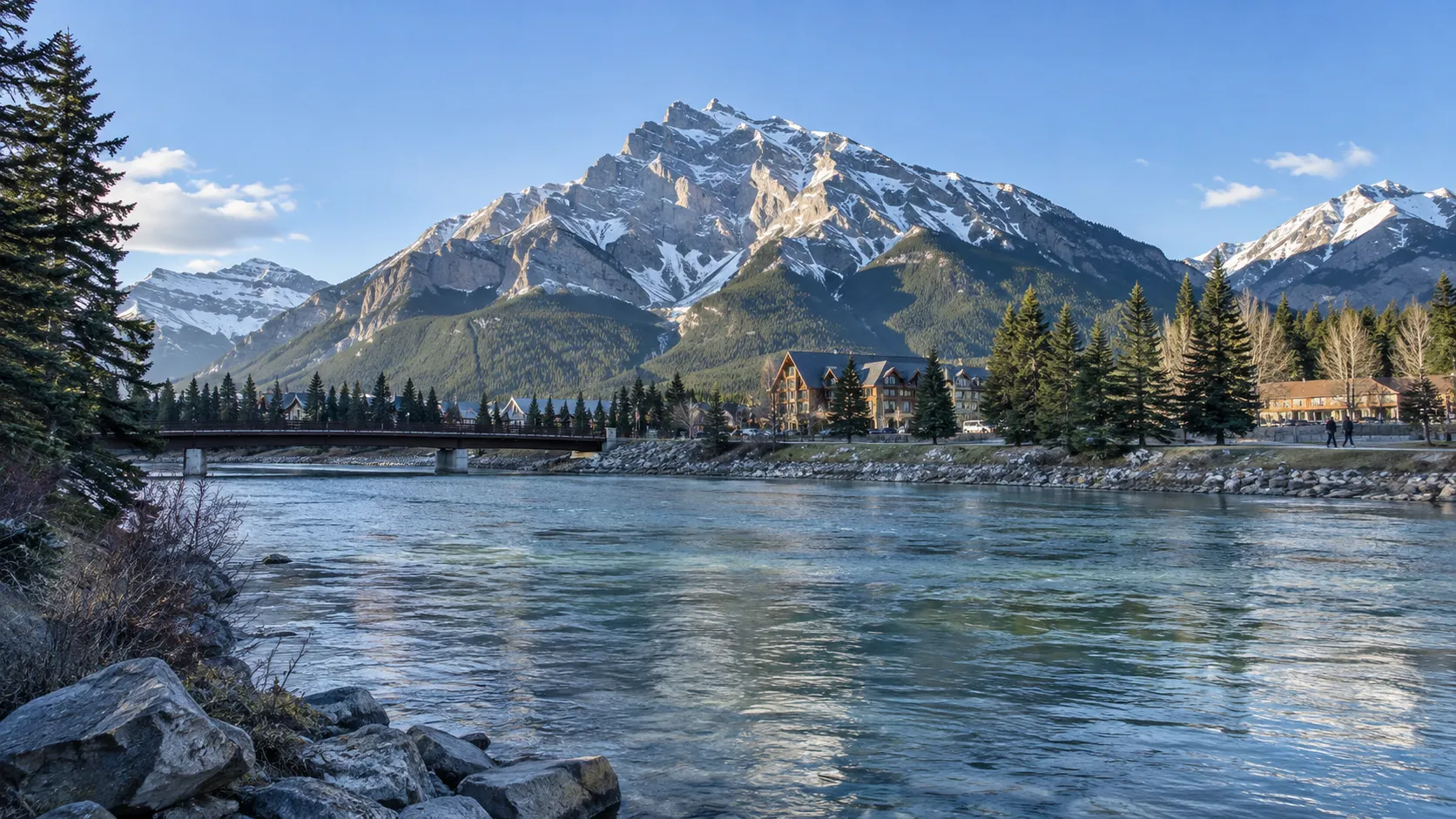 Bow River flowing through Banff beneath Cascade Mountain on a clear morning