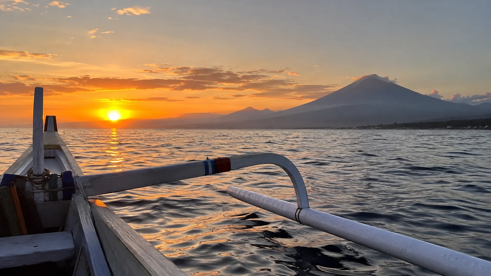 Traditional jukung fishing boat on the water at sunrise near Amed.