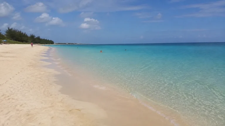 Pale sandy beach beside clear turquoise water.