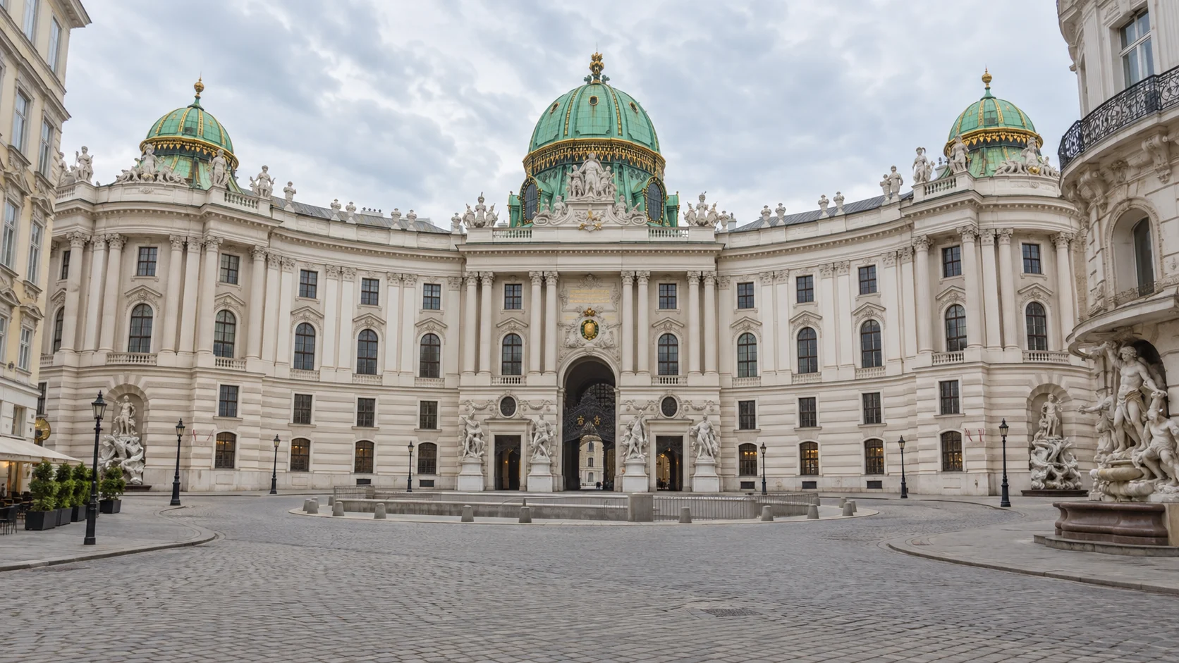 The curved Hofburg Palace facade and green dome across Michaelerplatz in Vienna.
