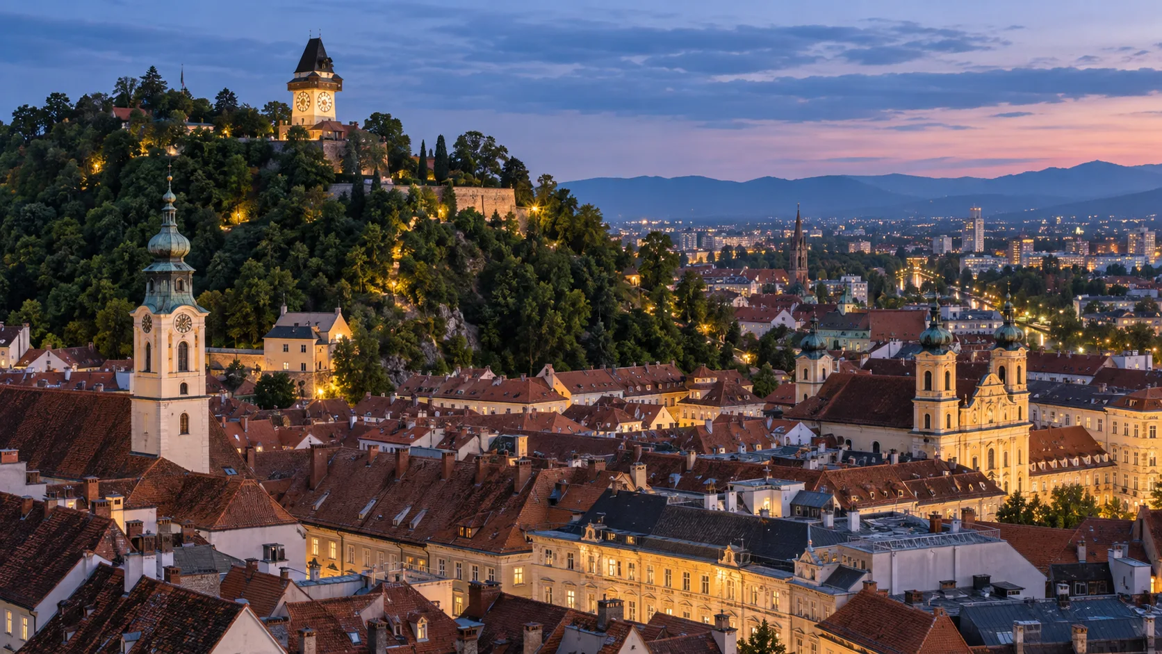 Graz's Schlossberg clock tower above red-roofed Old Town at blue hour.