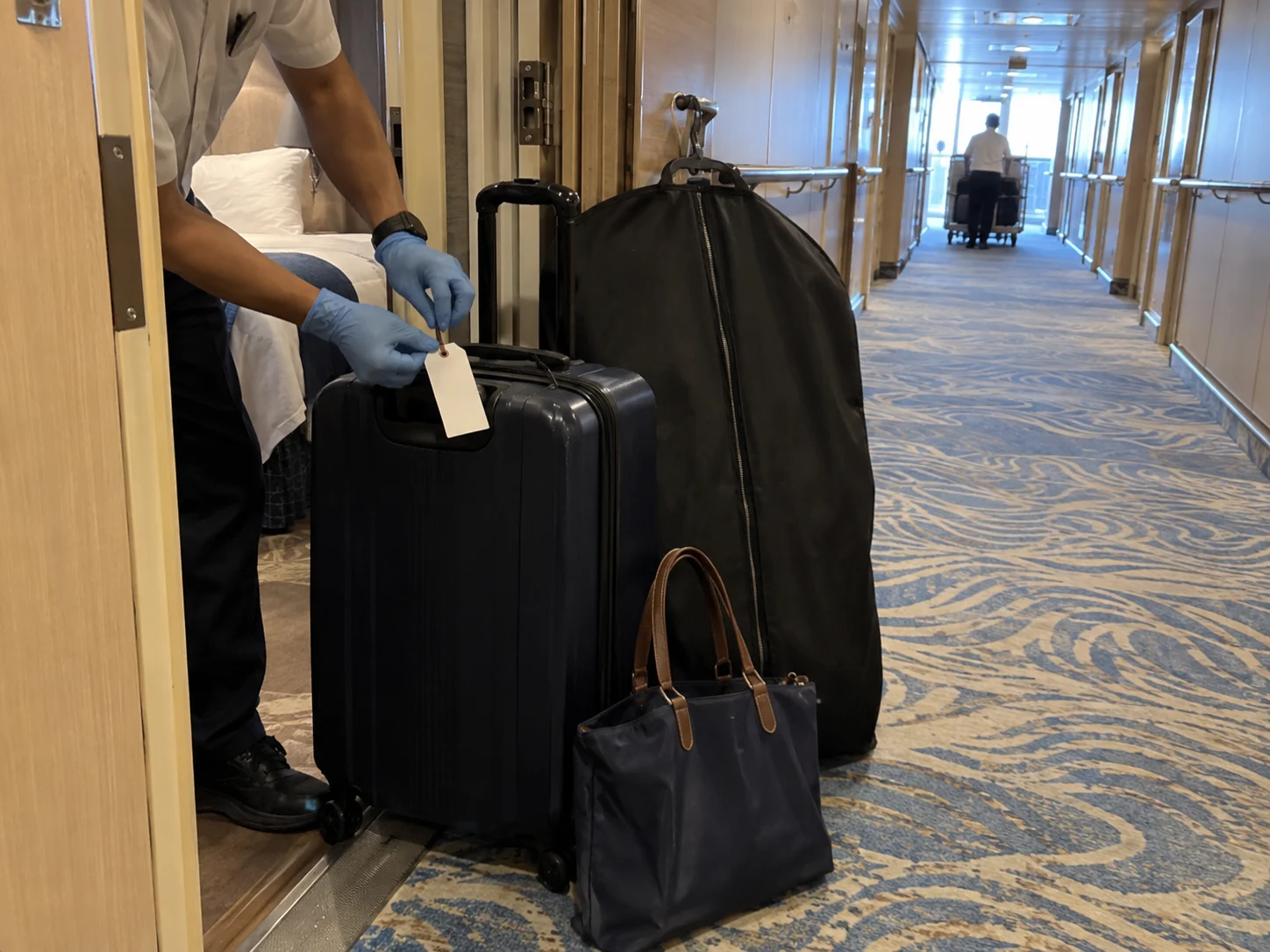 Packed suitcase and garment bag ready to be moved between cruise cabins
