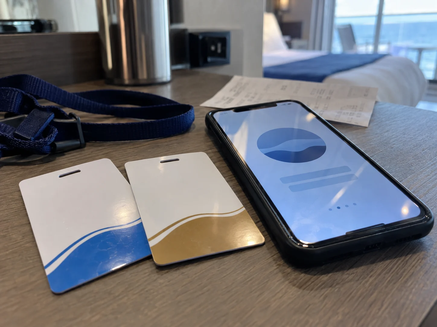 Two cruise key cards beside a phone showing a fresh onboard account screen