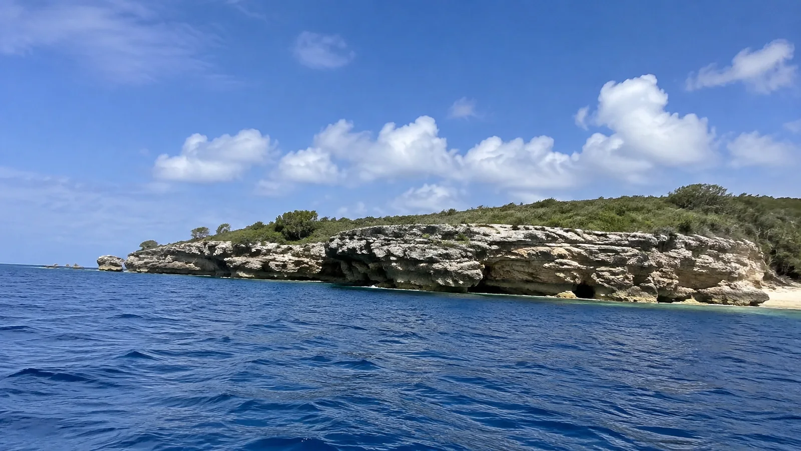 Low rocky island surrounded by deep blue water.