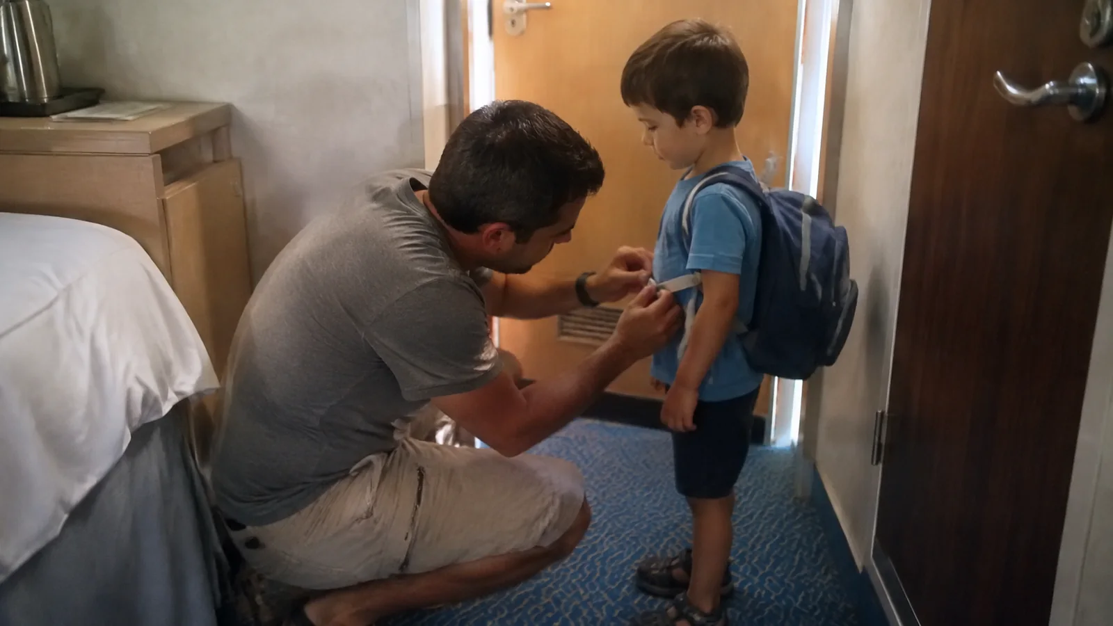 Parent helping a child with a wristband before leaving a cabin.