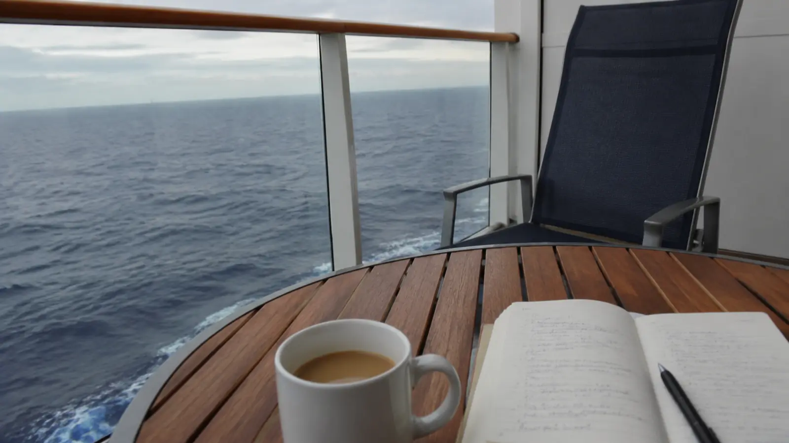 Coffee cup and open notebook on a cruise ship balcony table