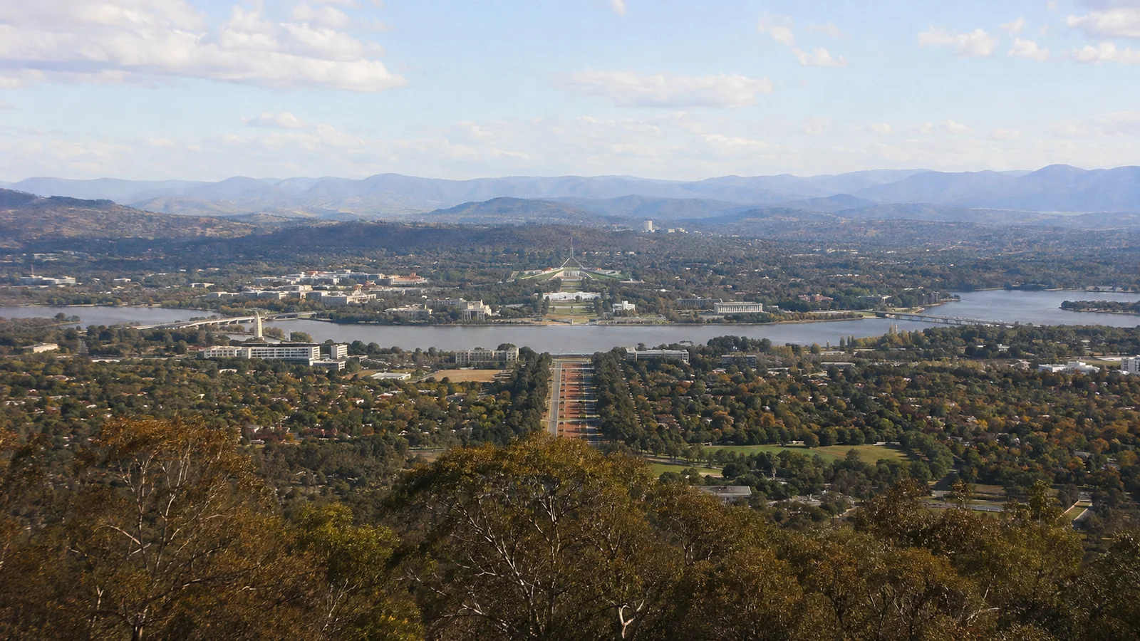 Elevated view of a city arranged around a broad lake.