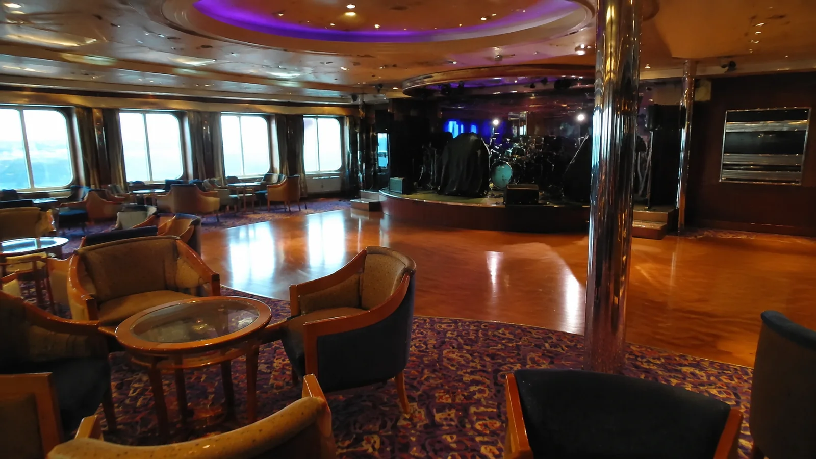 Empty lounge seating surrounds a polished wooden dance floor.