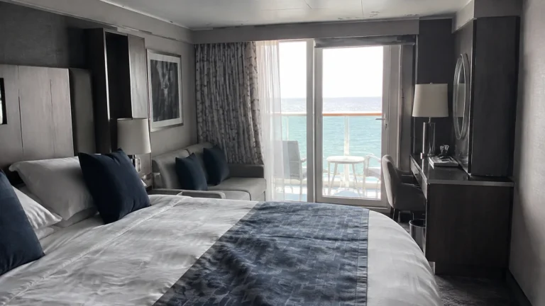Double bed and sitting area lead to an ocean-view balcony.