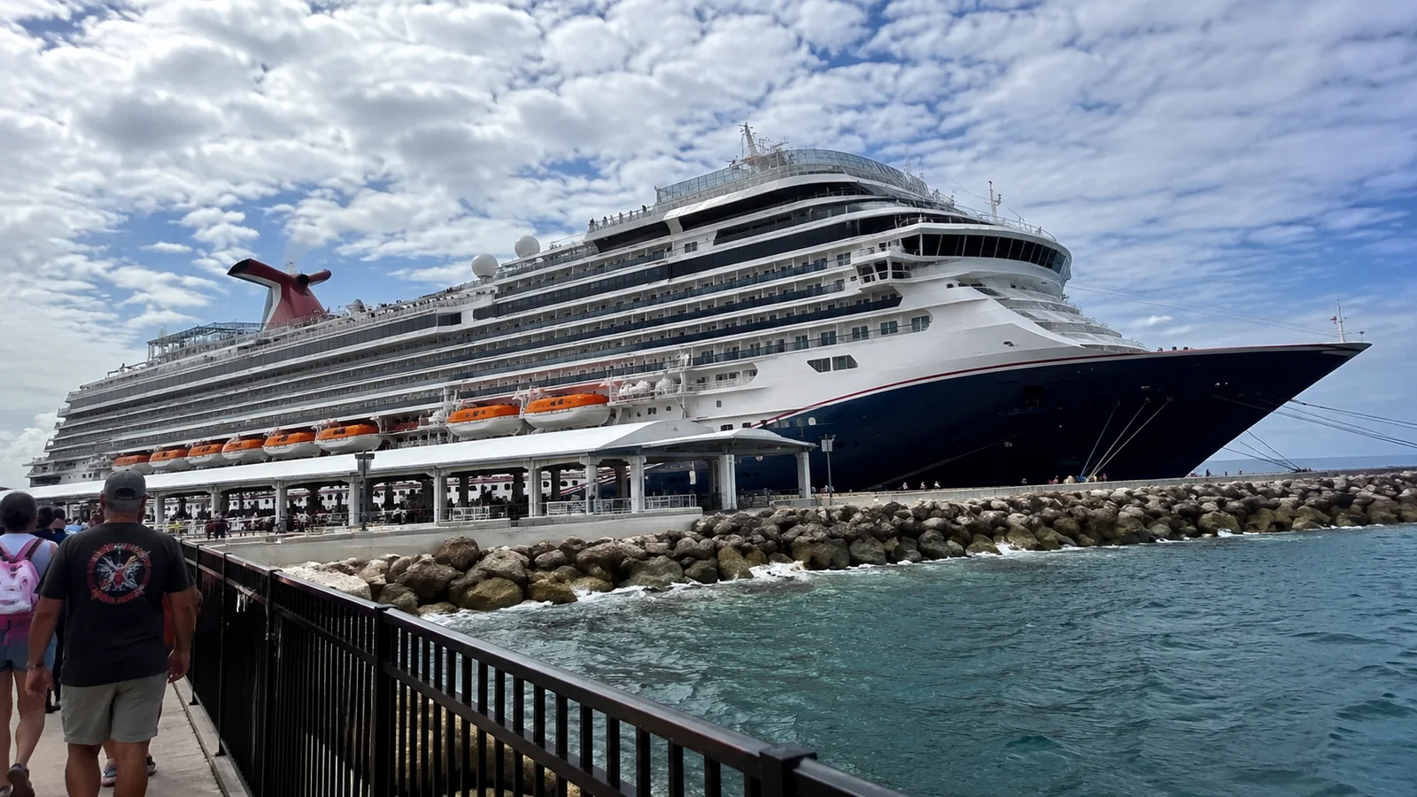 Large cruise ship docked beside a pier