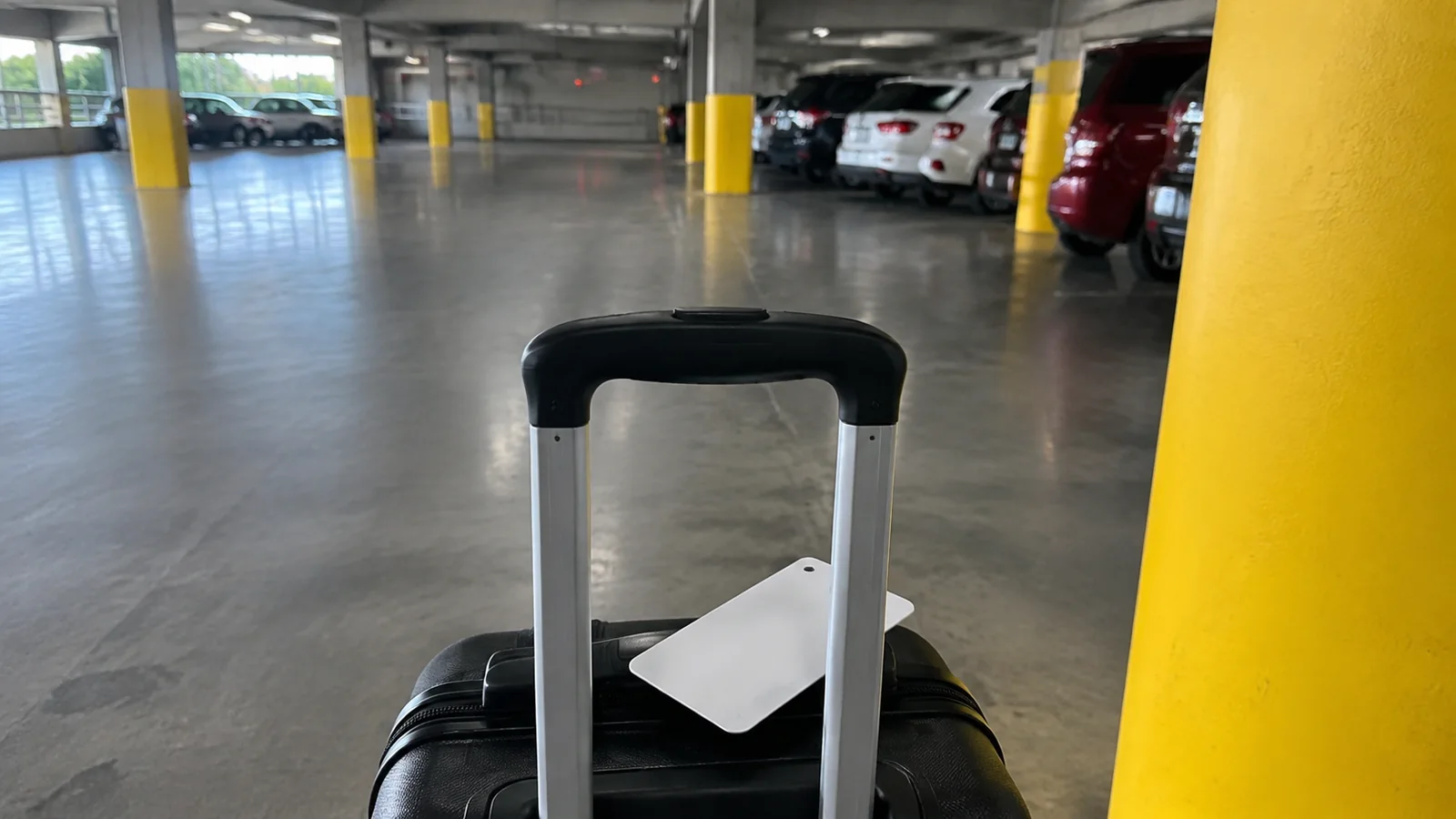 Tagged rolling suitcase inside a parking garage