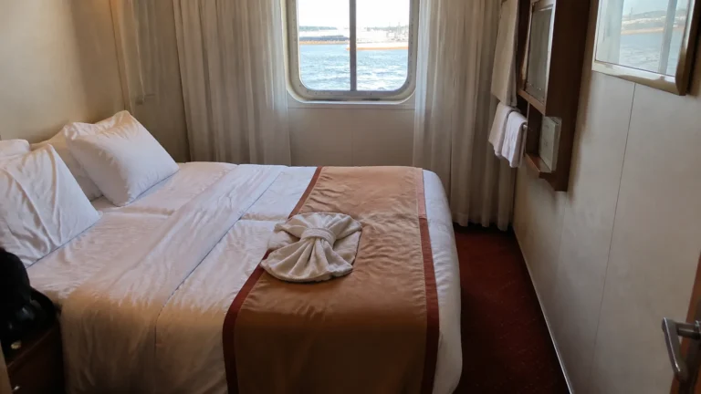 Cruise cabin with a double bed and ocean-view window