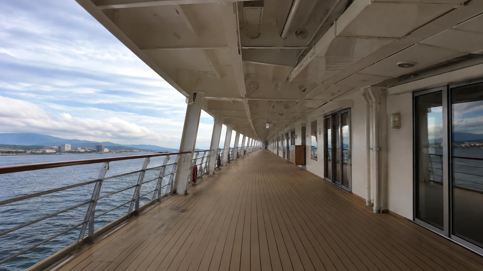 Empty covered promenade extends along the side of a ship.