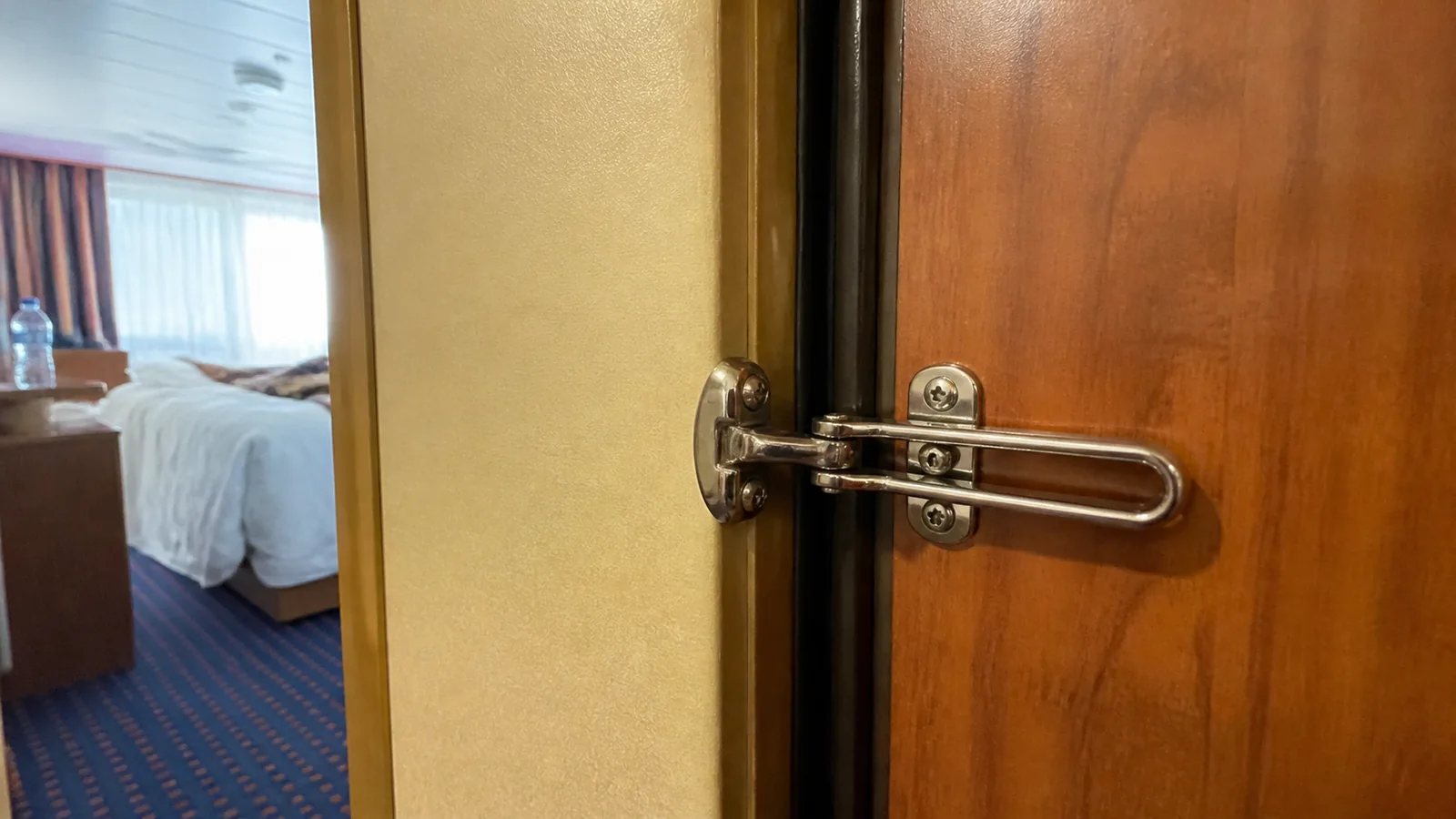 Close-up of a security latch on a connecting cruise cabin door