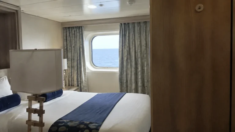Double bed beneath a sea-view window in a compact cabin.