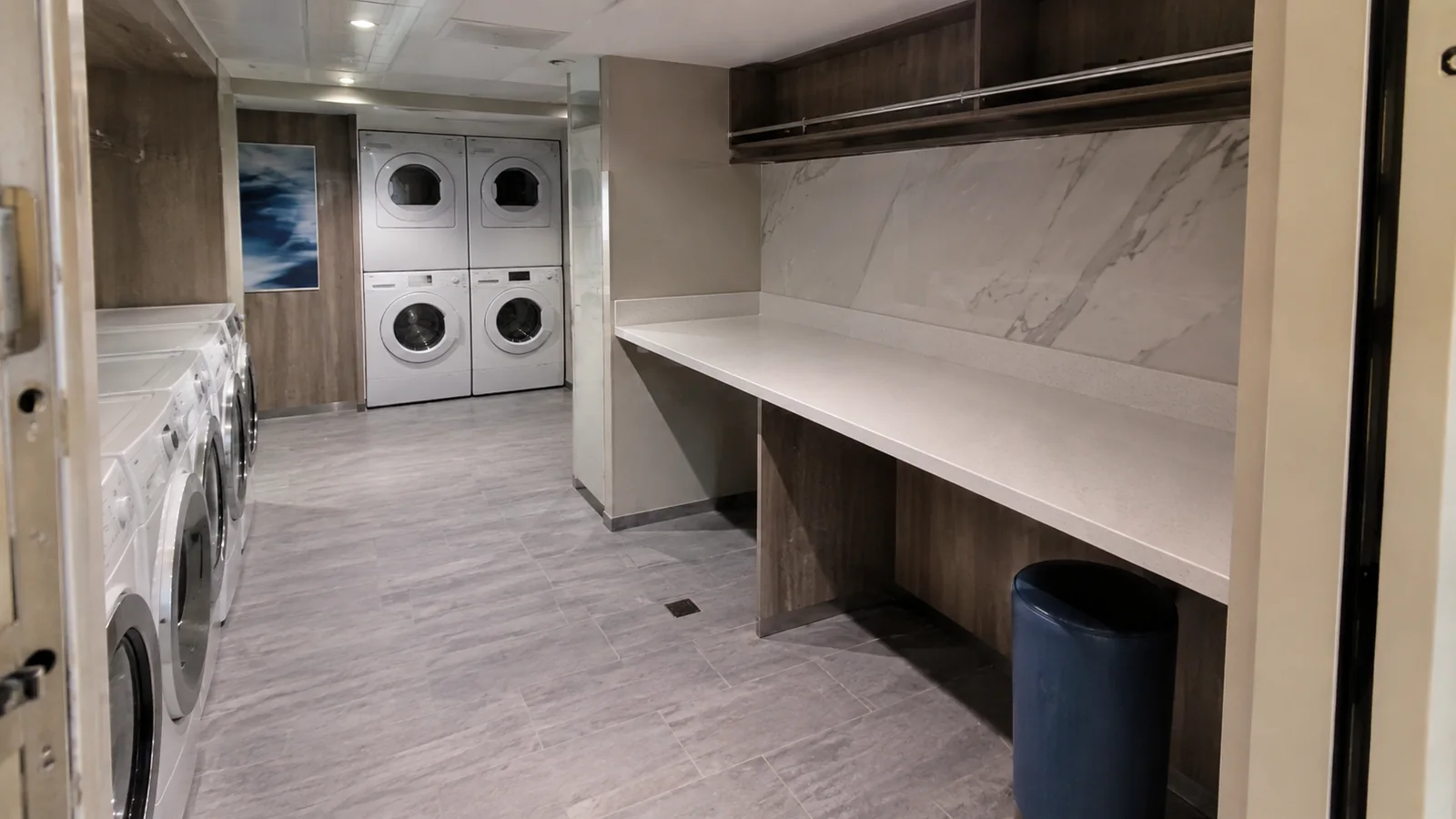 Laundry room with washers, dryers, and a long folding counter.