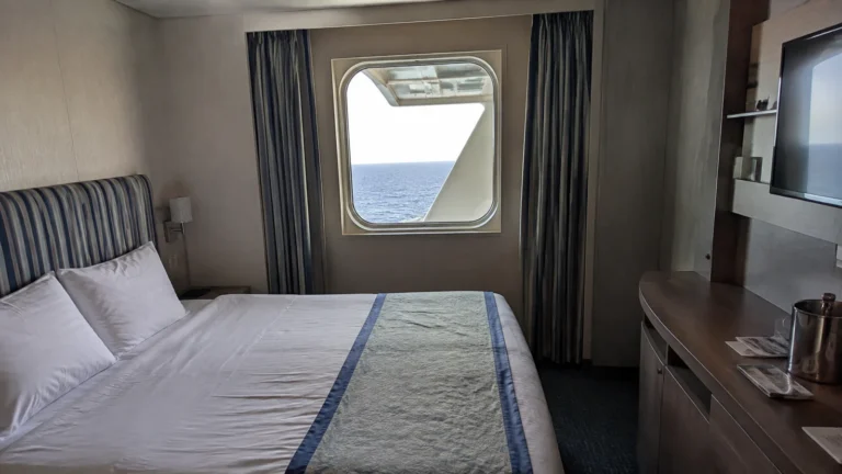 White structural beam partly obstructs the window in a compact stateroom.