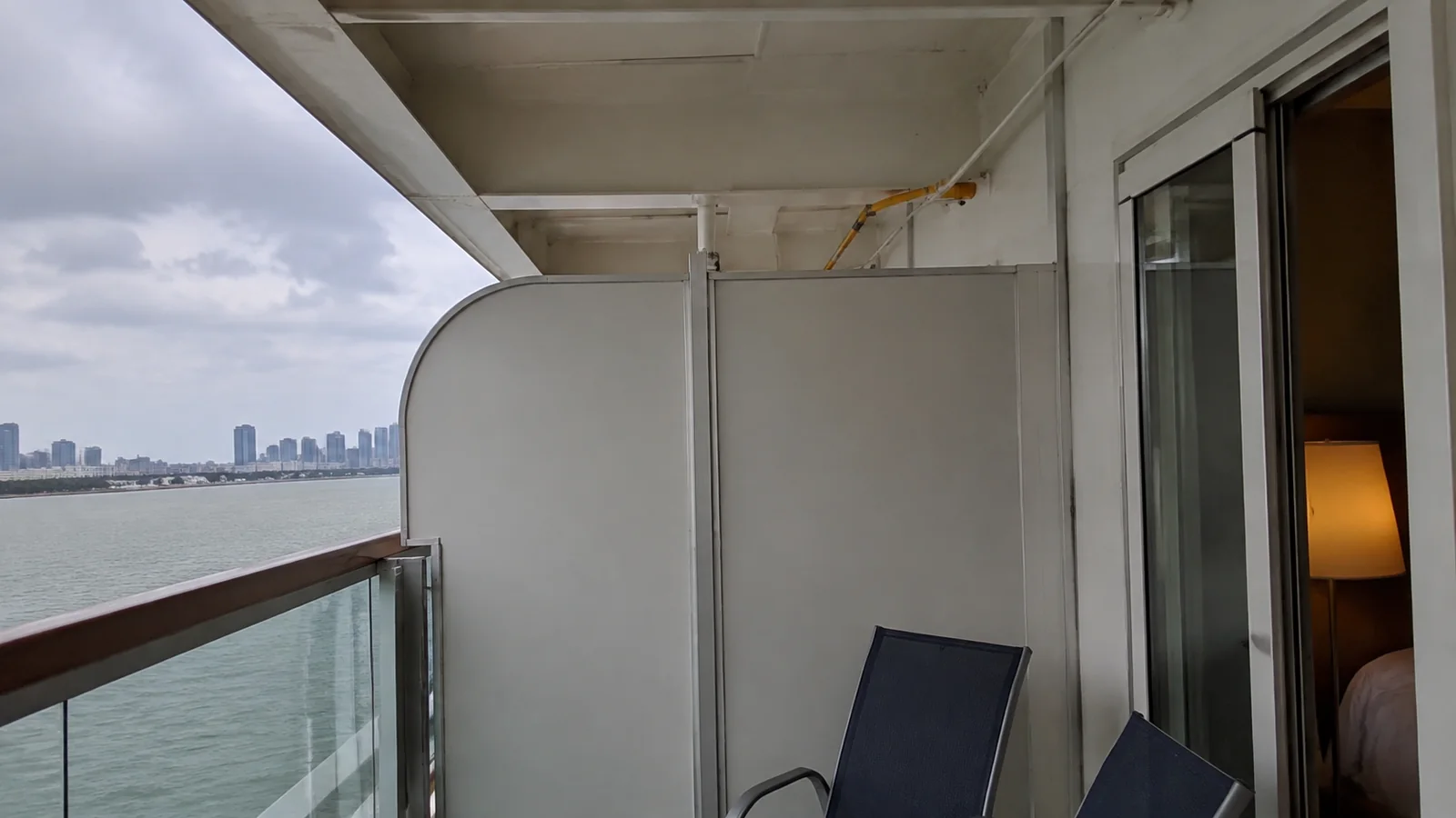 Sheltered balcony contains a chair and tall side partition.
