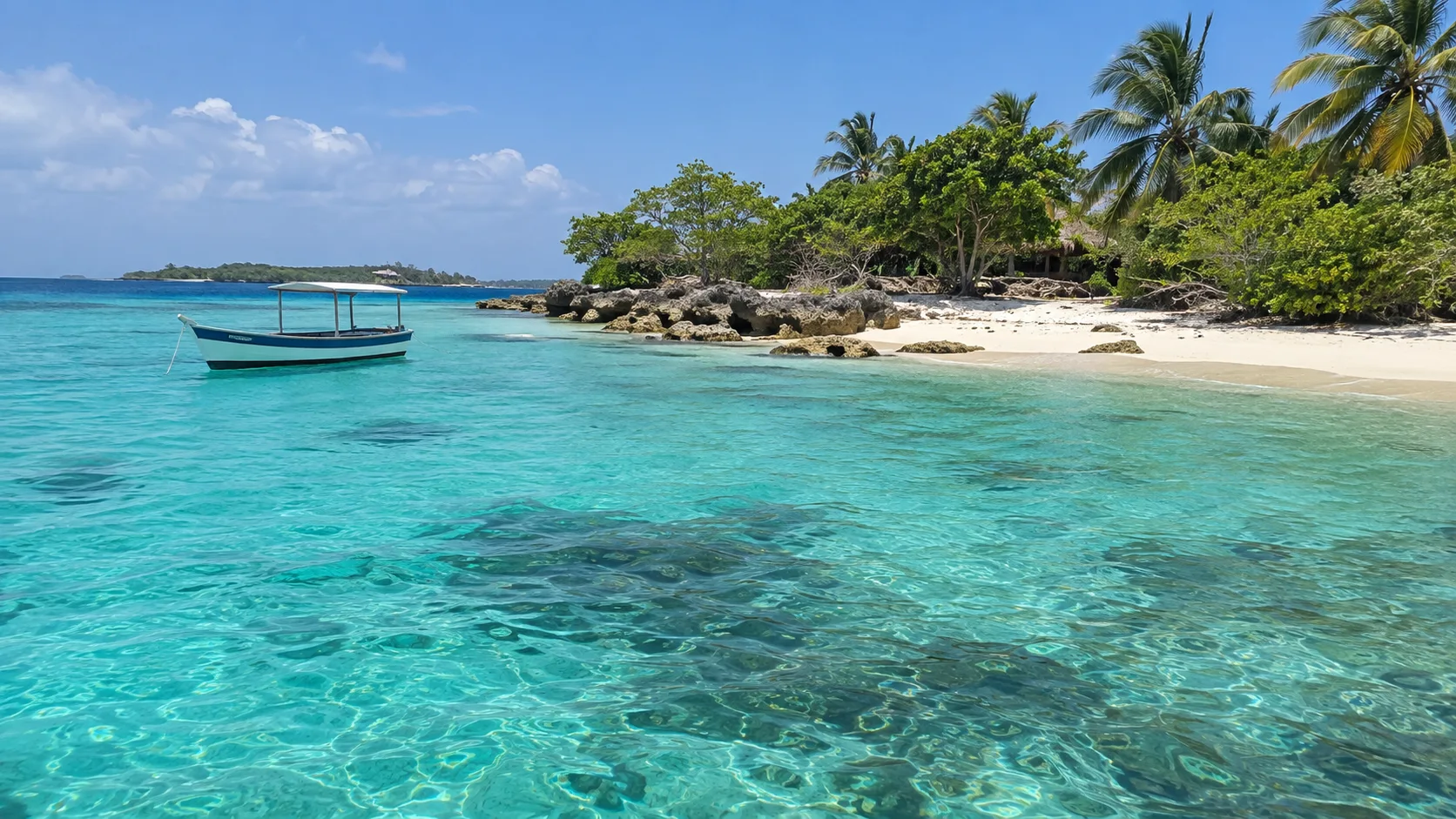 Turquoise water, coral shore, and a small boat in the Rosario Islands.