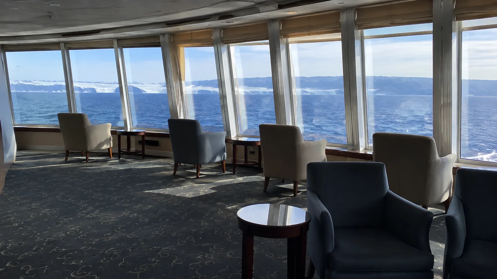Armchairs face floor-to-ceiling windows overlooking the water.