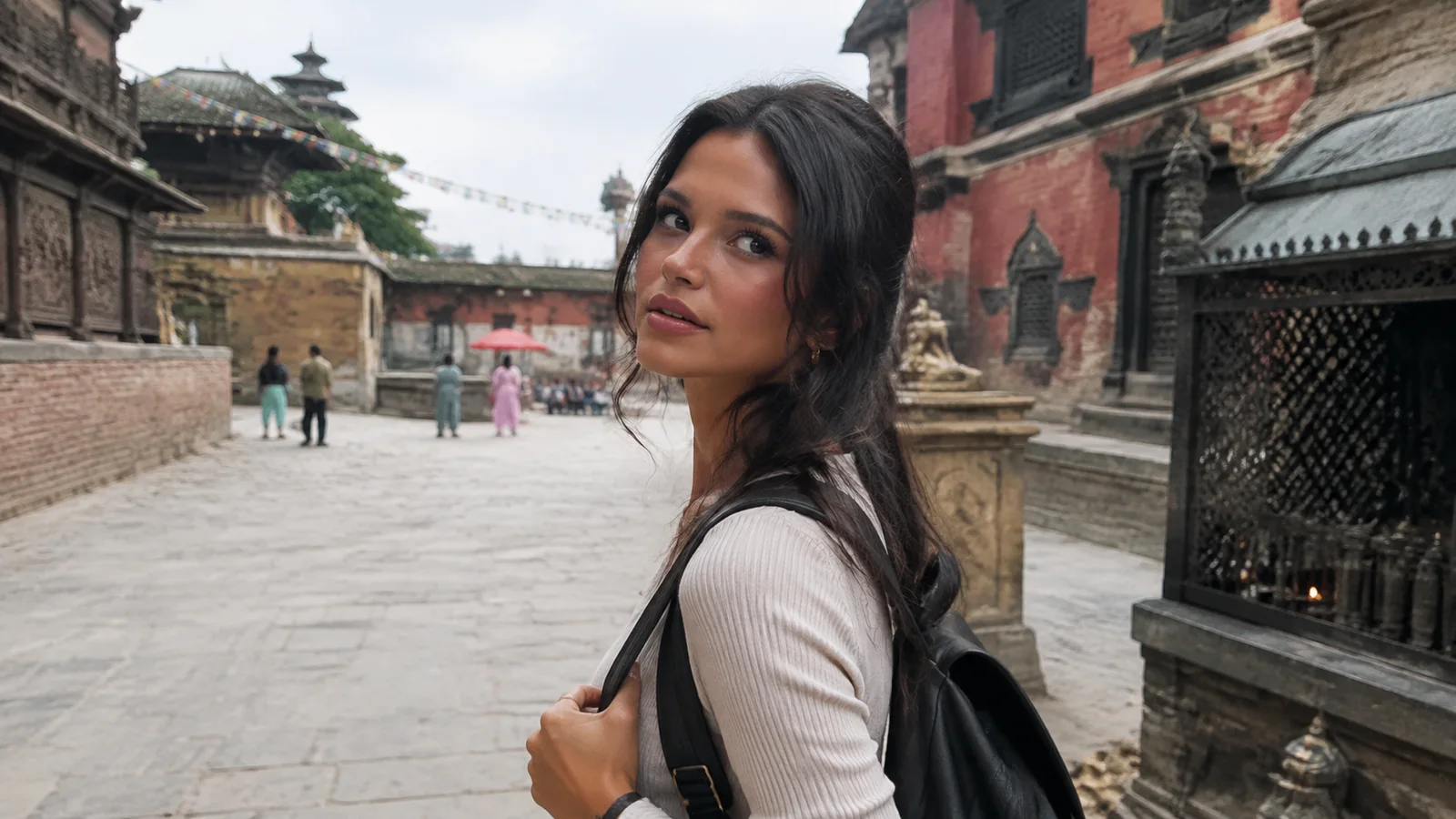Traveler standing in a brick-paved square surrounded by traditional temples.
