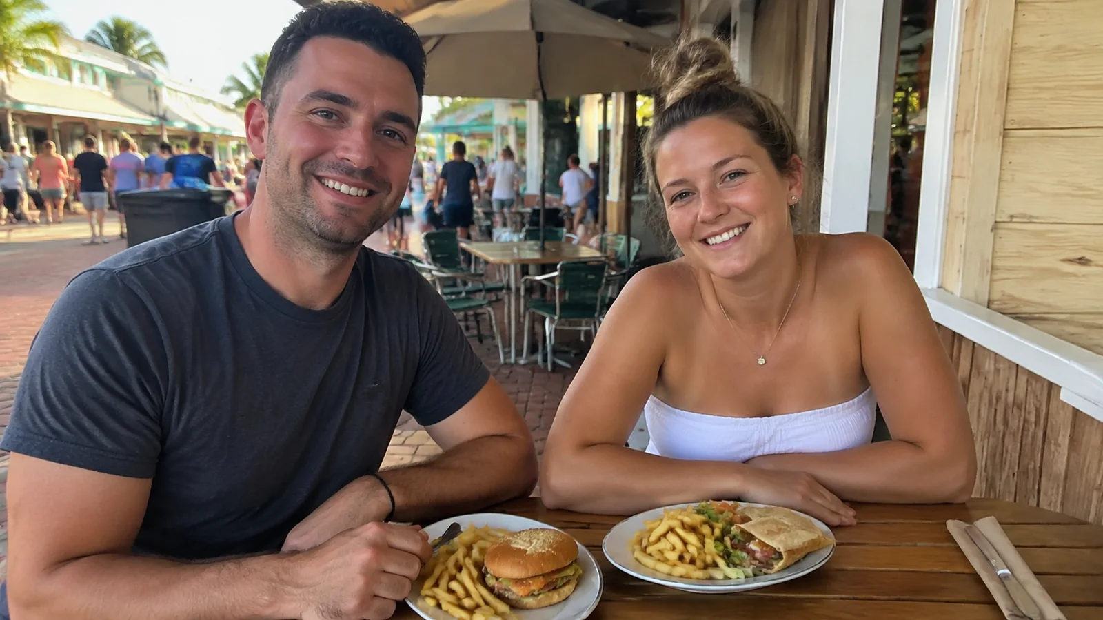 Couple sitting together over a meal at a casual outdoor restaurant.