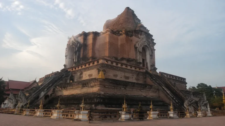 Large weathered brick temple rises above stone stairs and terraces.