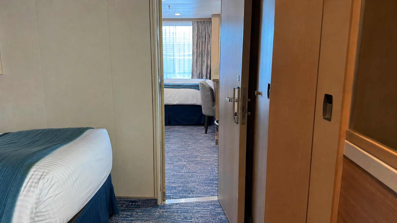 Open interior doorway connects two staterooms with beds visible.