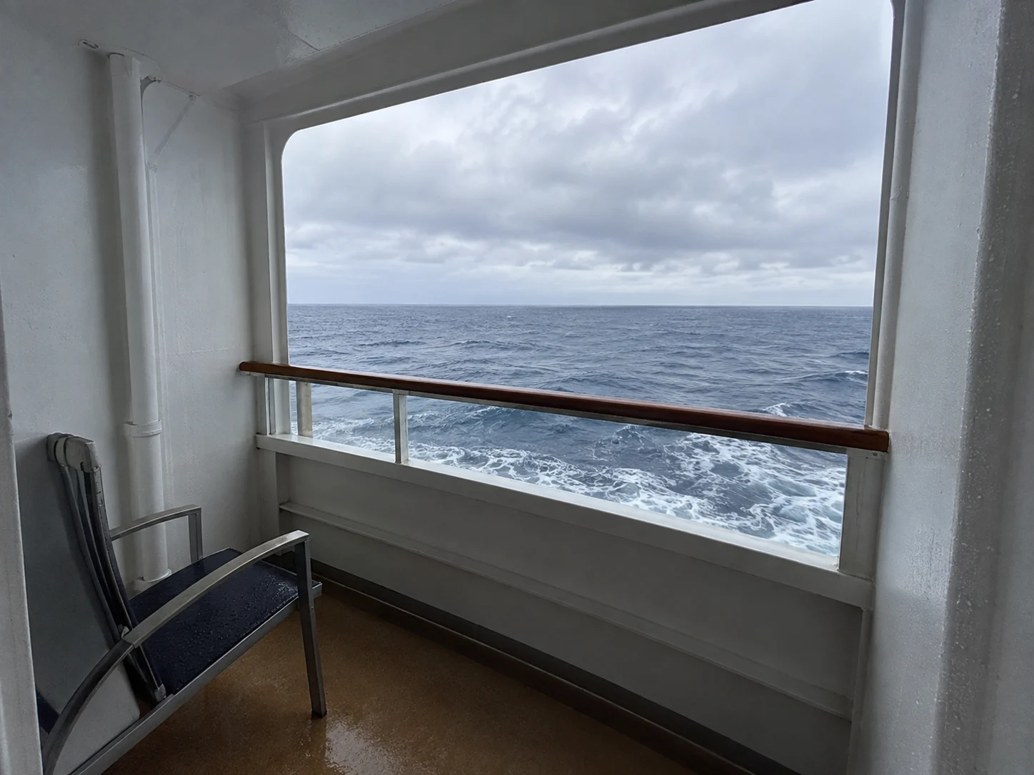Sheltered cove balcony recessed into a cruise ship hull close to the water.