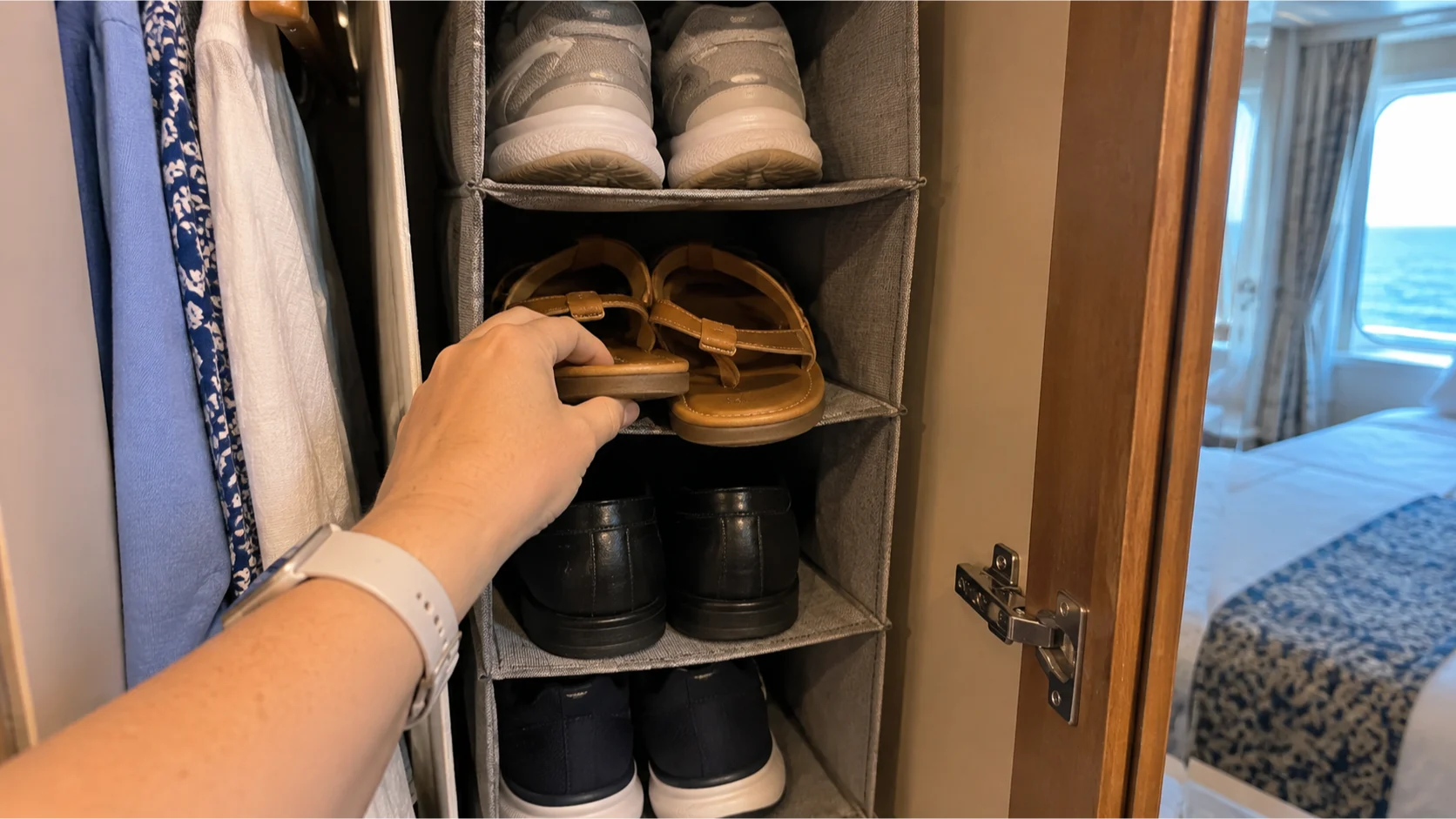 Shoes stored vertically in a compact hanging organizer inside a cruise cabin closet