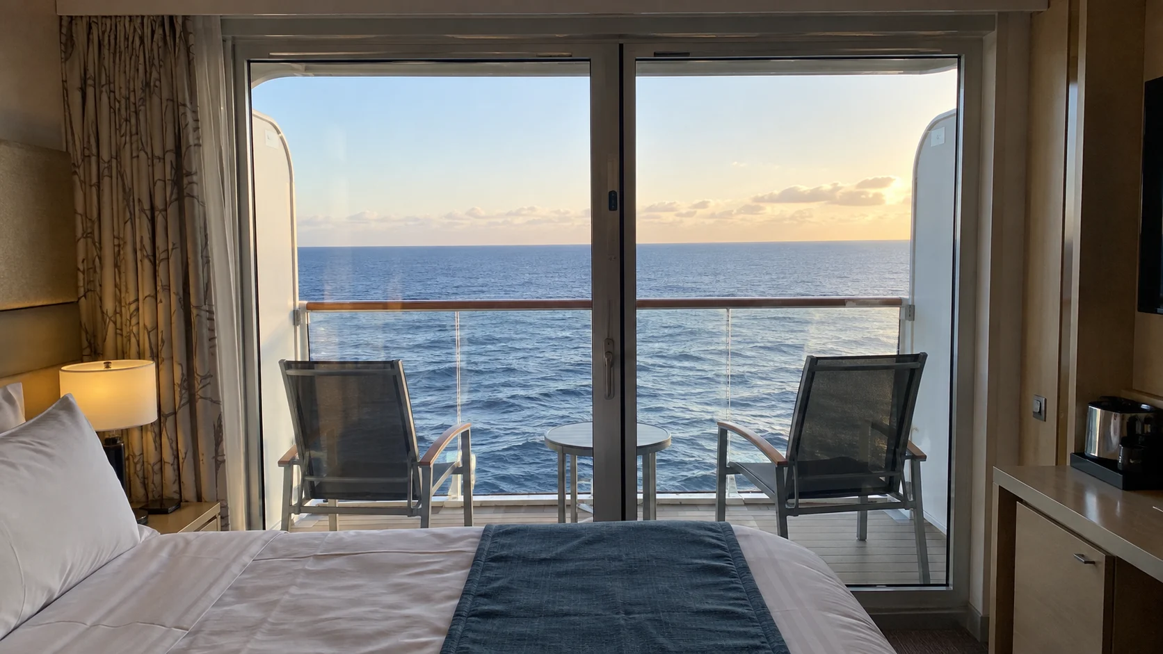 Closed cruise cabin balcony door with outdoor chairs positioned securely before departure