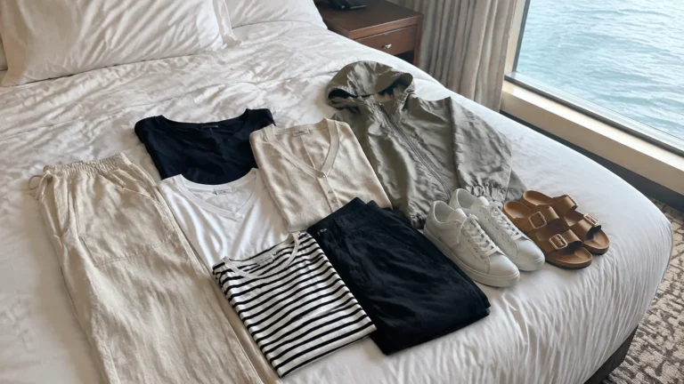 Coordinating tops, trousers, sneakers and sandals laid out on a cabin bed.