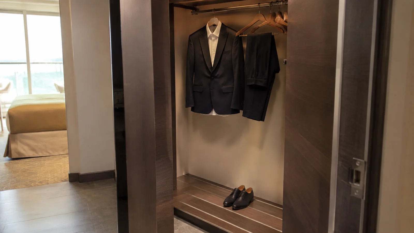 Formal jacket and trousers hanging in an open cruise wardrobe.