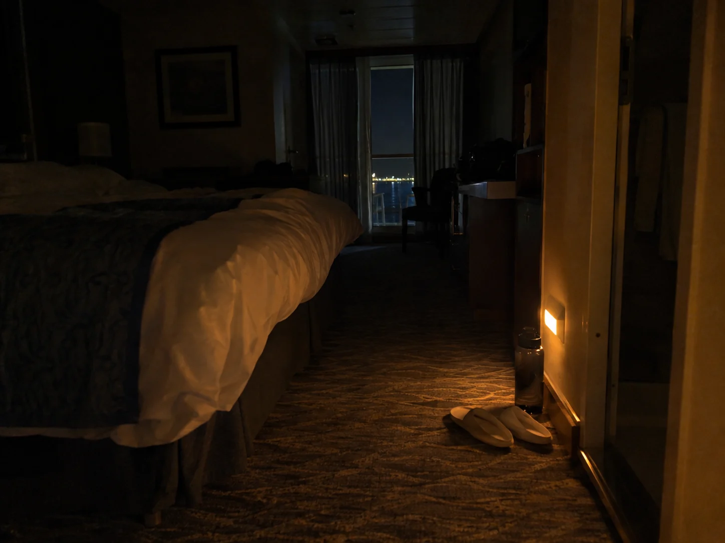 Motion-activated night-light illuminating the floor of a dark cruise cabin
