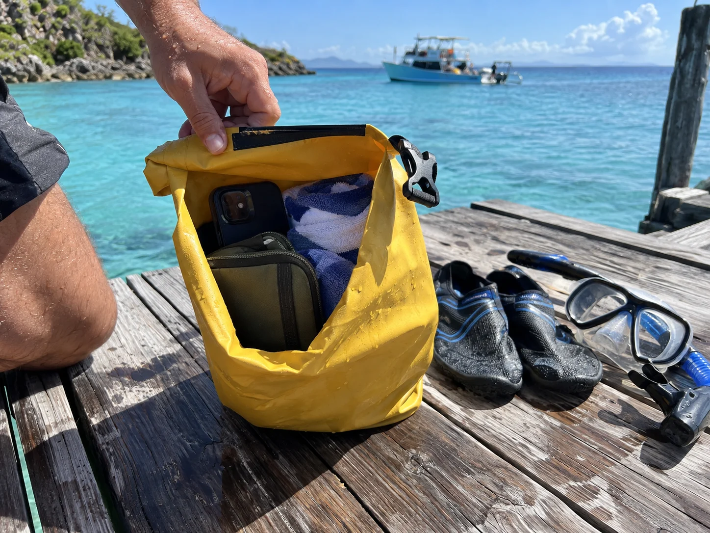 Small dry bag protecting a phone and towel during a beach excursion
