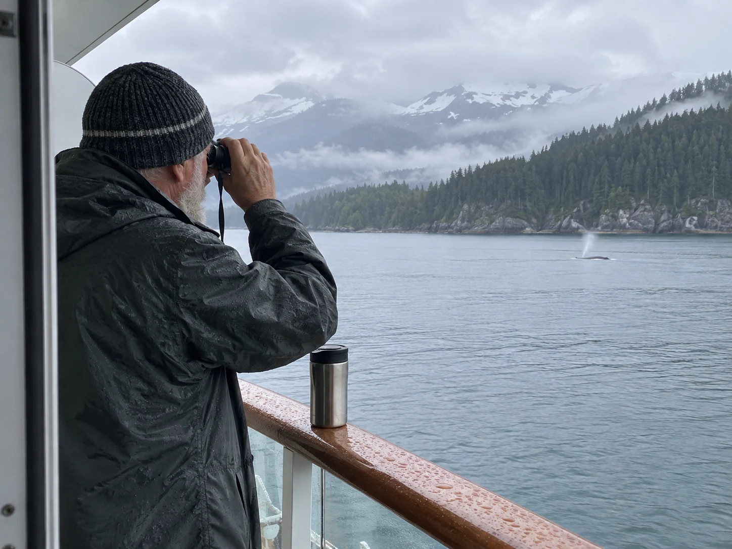 Cruise traveler using compact binoculars to watch wildlife from a balcony