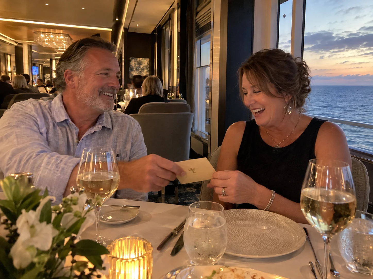Couple enjoying a gifted specialty dinner at a softly lit cruise restaurant