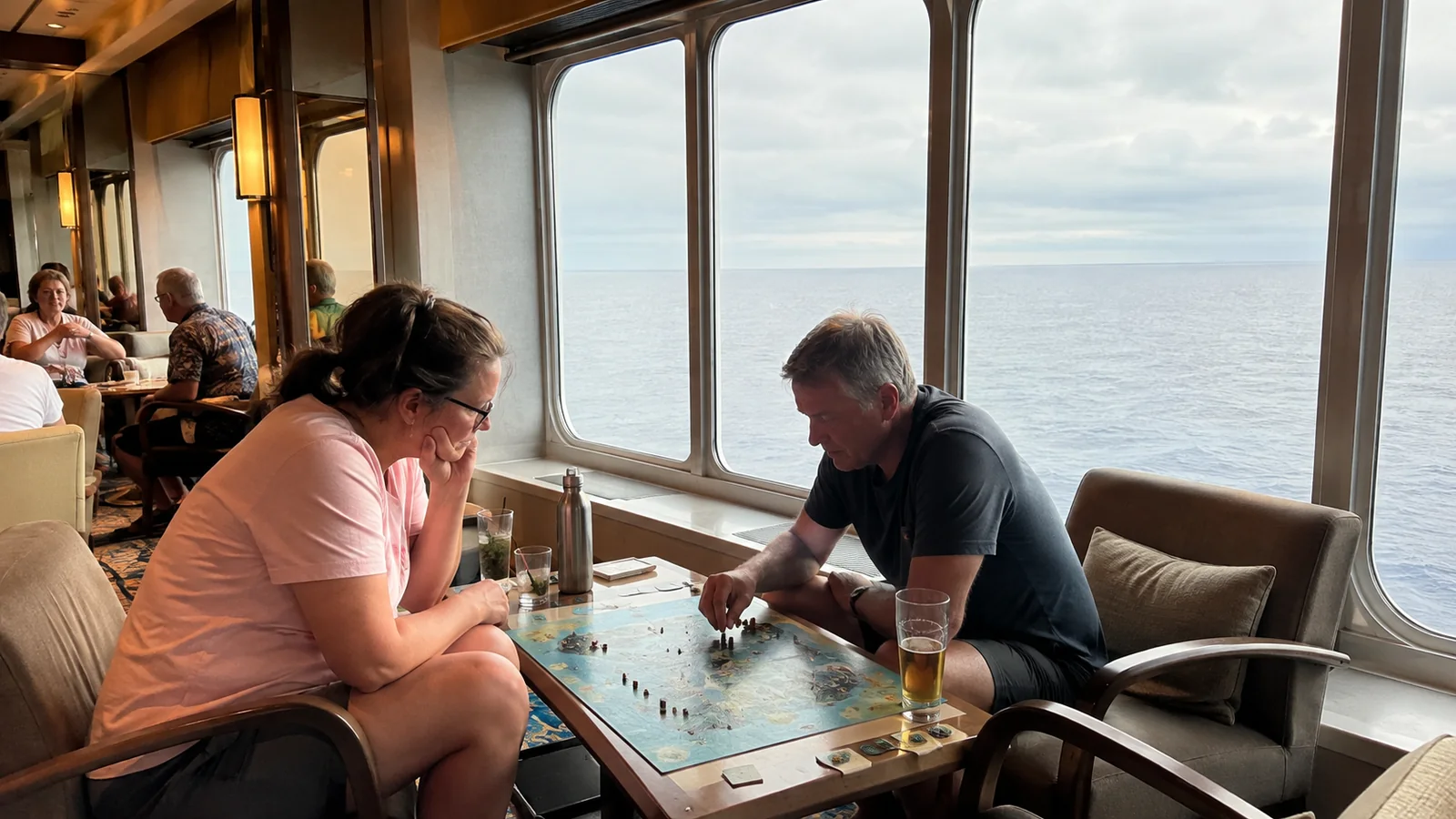 Two passengers play a board game beside ship windows.